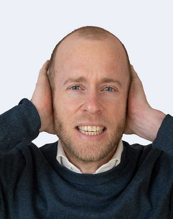 Roel van Gorkum, MSc BioMedical Engineer en oprichter van Still Tinnitus houdt zijn handen over zijn oren om te laten zien hij vroeger last had van oorsuizen