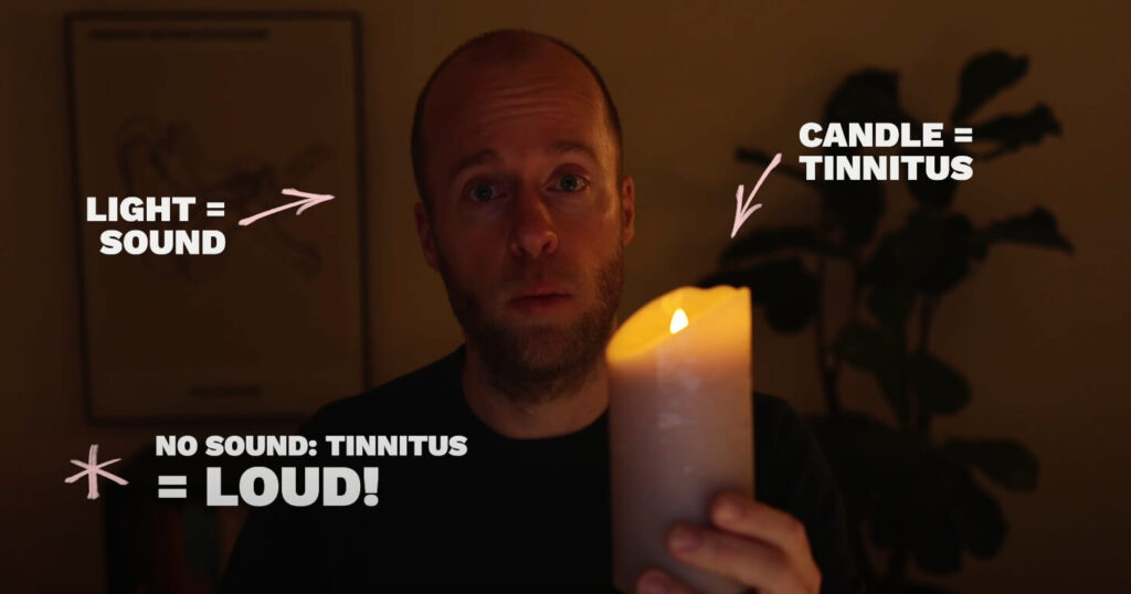 Roel van Gorkum holding a candle in a dark room, to illustrate that in a quiet environment, the tinnitus is heard more loudly because it is the only thing you can focus on.