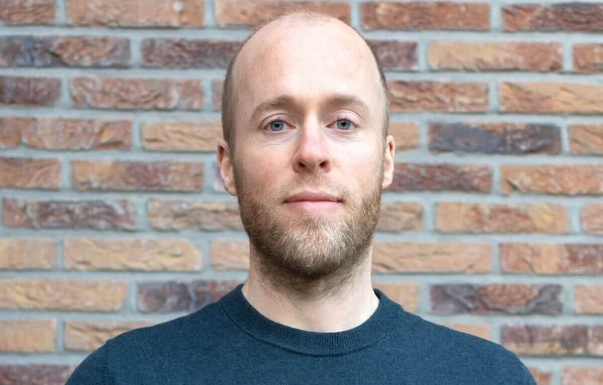 Close-up of Roel van Gorkum standing in front of a brick wall