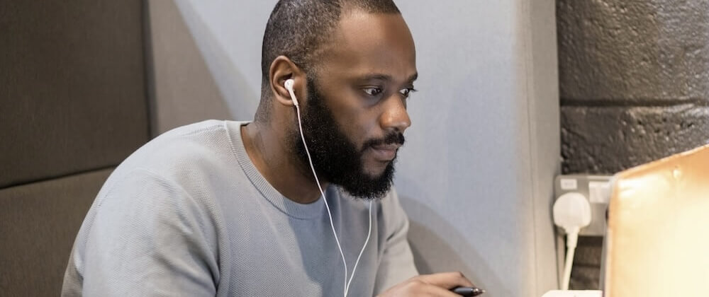 Persoon die aan een bureau op een laptop werkt met zichtbaar lesmateriaal van de Sus Tinnitus cursus, ter illustratie van betrokkenheid bij het online tinnitusbehandelprogramma en de studieactiviteiten.